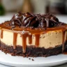 Decadent caramel brownie cheesecake topped with caramel sauce and chocolate drizzle.