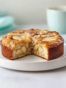 Delicious Cinnamon Apple Cake topped with a sprinkle of cinnamon and fresh apples.