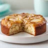 Delicious Cinnamon Apple Cake topped with a sprinkle of cinnamon and fresh apples.