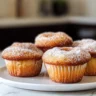Freshly baked cinnamon donut muffins with a golden crust and sprinkled with sugar