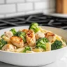 Creamy chicken and broccoli pasta dish garnished with parmesan cheese.