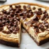 Deep Dish Cookie Dough Cheesecake Pizza topped with chocolate chips and cookie dough