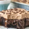 Deliciously moist Chocolate Poke Cake topped with chocolate pudding and whipped cream.