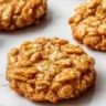 Freshly baked Peanut Butter Cornflake Cookies on a cooling rack.