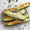 Zucchini fries with Parmesan cheese served on a plate.