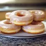 Freshly made glazed doughnuts on a platter