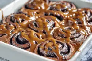 Freshly baked Chocolate Cinnamon Rolls topped with rich chocolate glaze