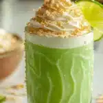 Delicious Coconut Key Lime Pie Smoothie topped with lime slices and coconut flakes
