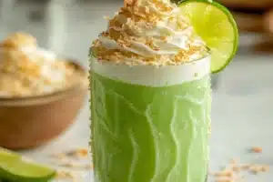 Delicious Coconut Key Lime Pie Smoothie topped with lime slices and coconut flakes