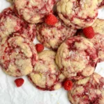 Freshly baked Lemon Raspberry Cookies on a plate with a lemon wedge.