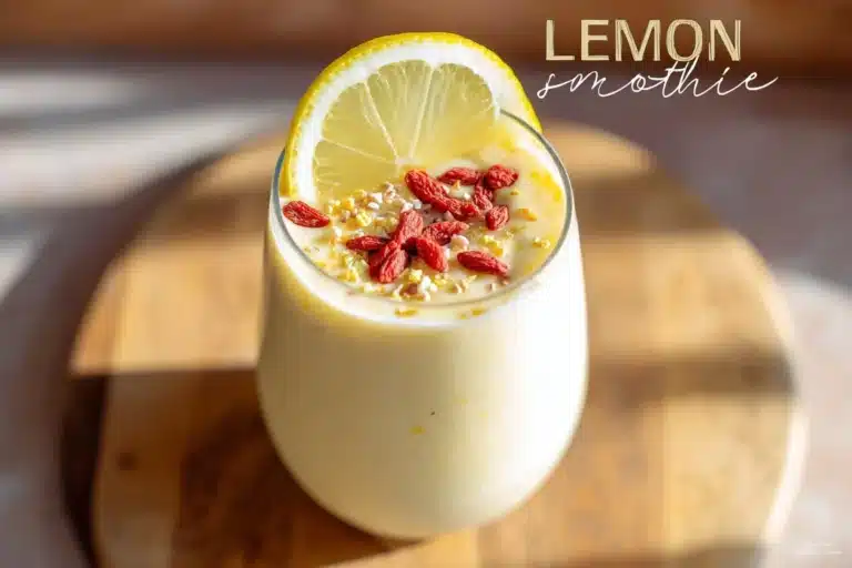 Lemon smoothie served in a glass with fresh lemons and mint garnish.