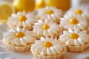 Delicious lemon tartlets served with fresh lemon slices on top.