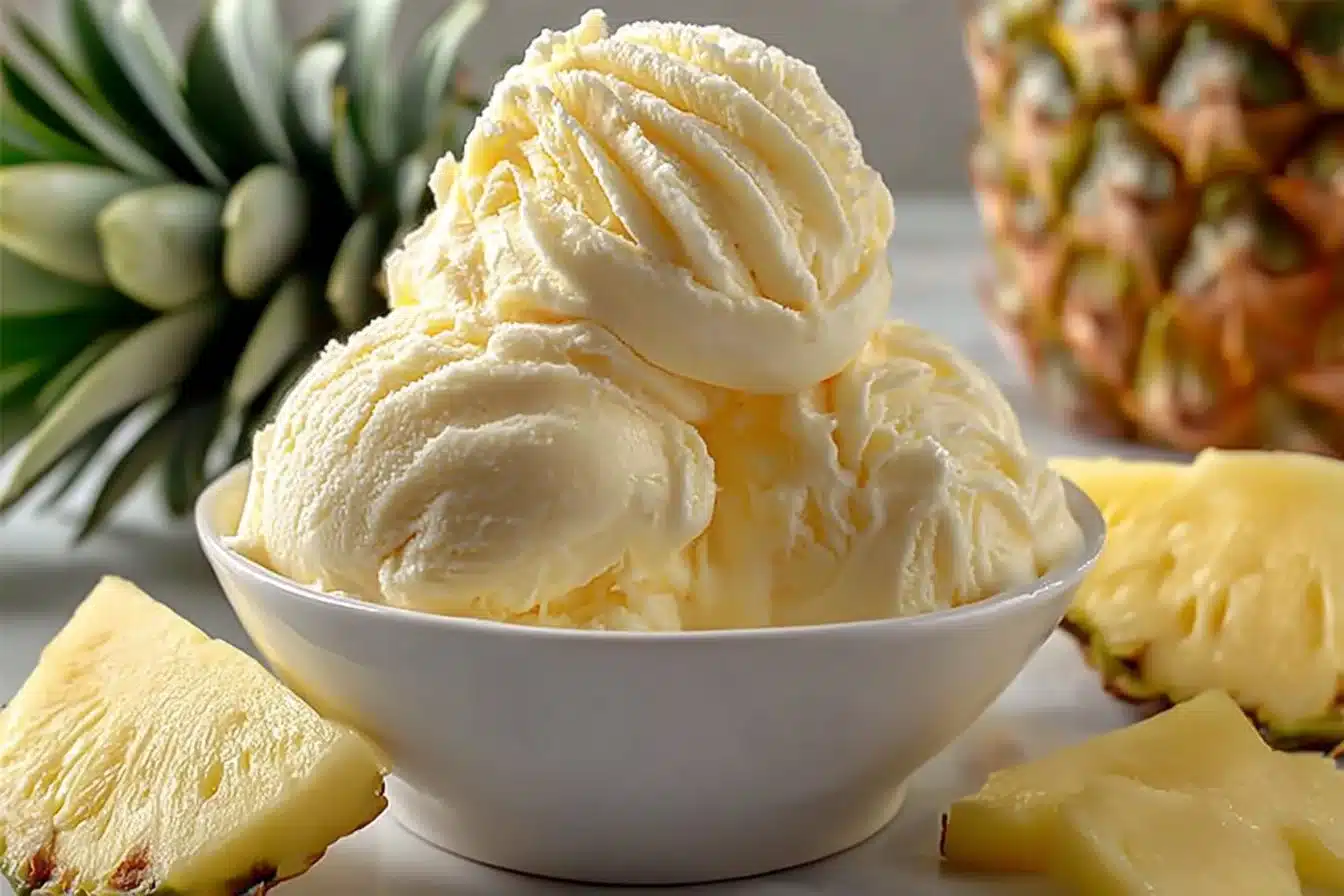 Bowl of homemade pineapple ice cream topped with fresh pineapple slices
