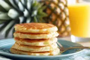 Delicious pineapple pancakes drizzled with coconut syrup on a plate