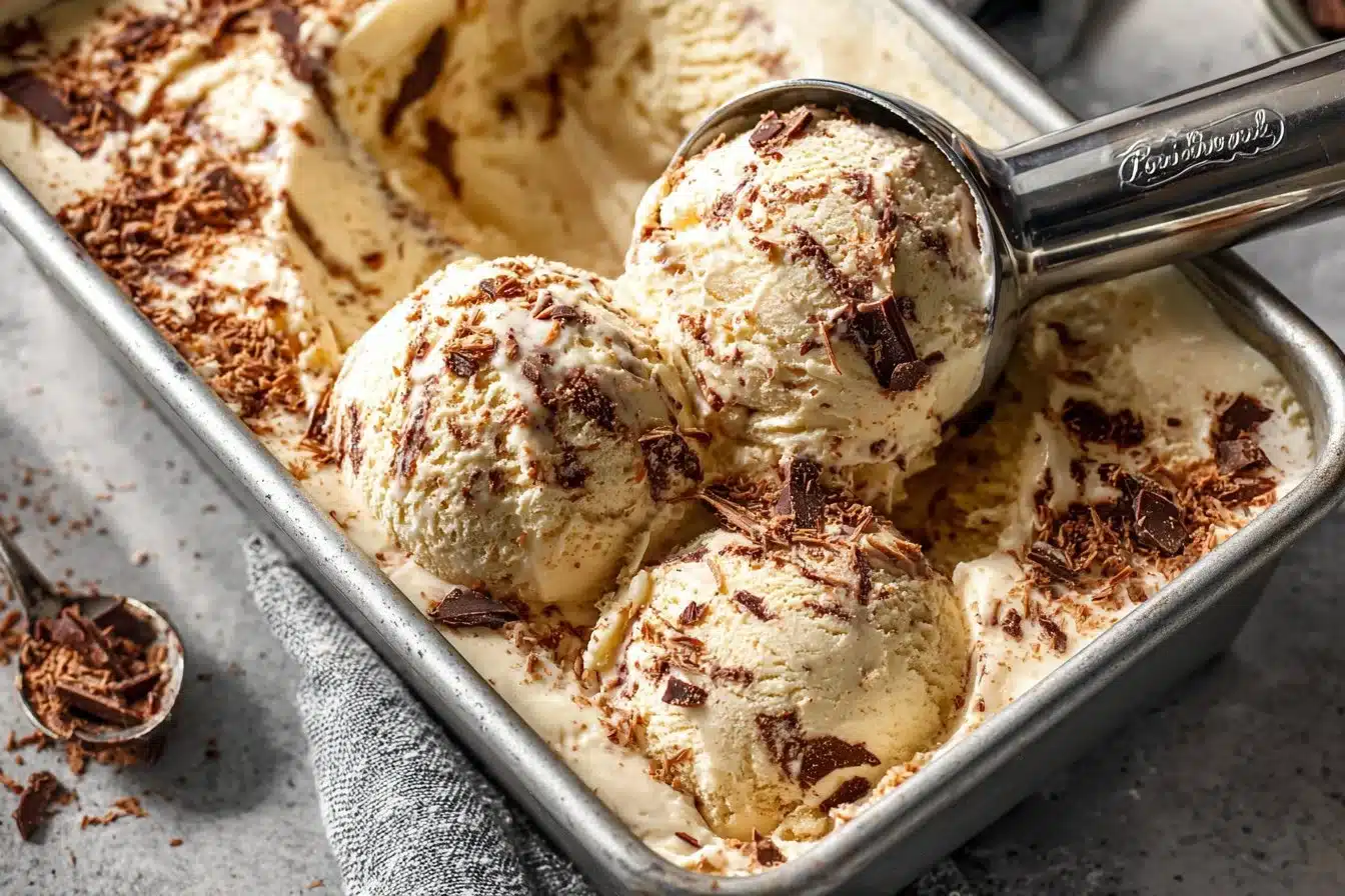A bowl of creamy tiramisu ice cream with coffee and cocoa powder topping.