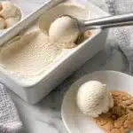 A bowl of creamy vanilla vegan ice cream topped with fresh fruit.