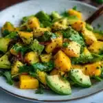 A colorful Avocado Mango Salad with fresh ingredients on a plate