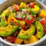 A vibrant avocado salad with fresh ingredients, showcasing flavors and color