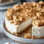 Sliced Cinnamon Toast Crunch Cheesecake with cereal topping on a plate
