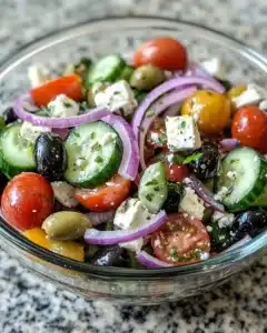 Fresh Cucumber Tomato Onion Salad in a bowl, garnished with herbs