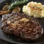 Garlic Butter Steak served with herbs and butter on a wooden platter.