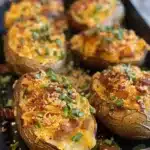 Delicious sliced baked potatoes with seasonings served on a plate.