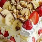 Deliciously layered Banana Split Cake with fresh bananas, whipped cream, and chocolate sauce.