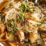 Bowl of Chicken and Shirataki Noodle Soup with fresh herbs and vegetables