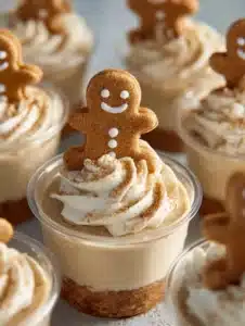 Delicious no-bake gingerbread cheesecake cups topped with whipped cream and spices.