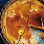 Slice of Bourbon Brûlée Pumpkin Pie with caramelized sugar topping on a plate