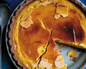 Slice of Bourbon Brûlée Pumpkin Pie with caramelized sugar topping on a plate