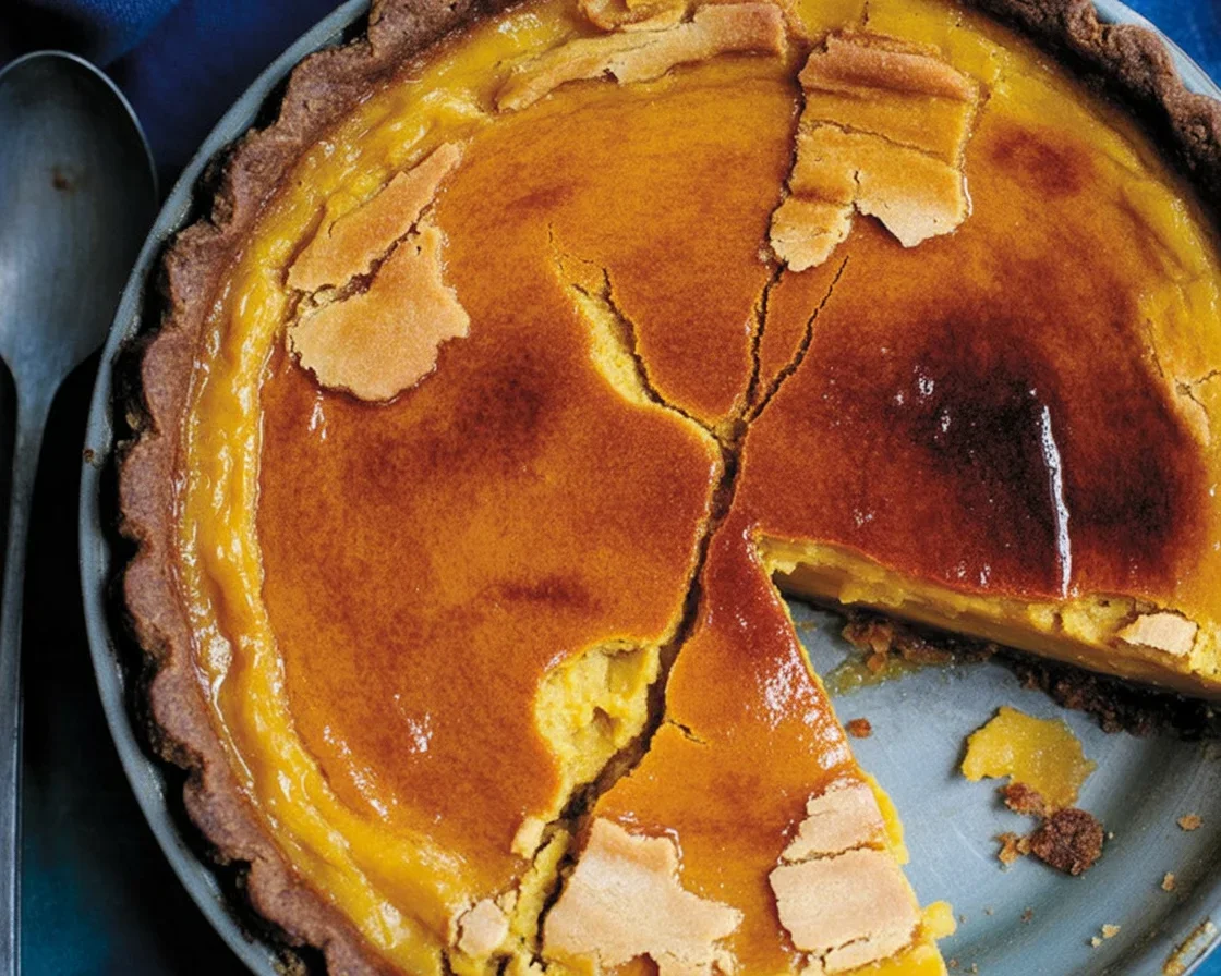 Slice of Bourbon Brûlée Pumpkin Pie with caramelized sugar topping on a plate