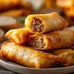 Delicious beef cheddar egg rolls served with dipping sauce on a platter