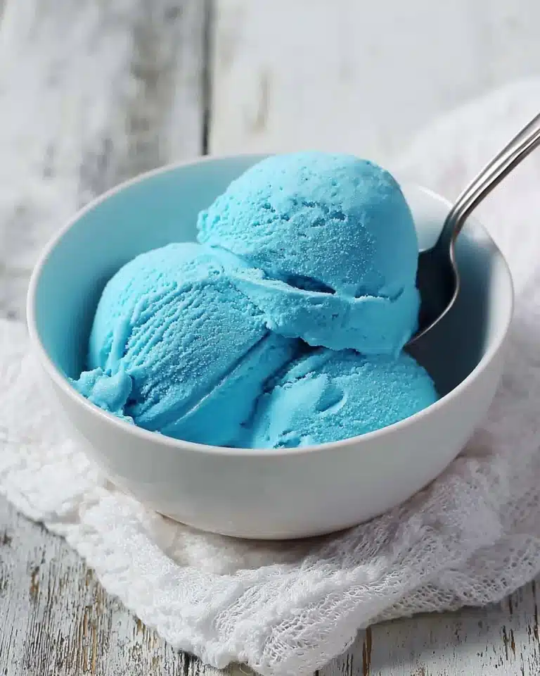 A scoop of Blue Moon Ice Cream in a waffle cone topped with sprinkles