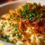 French Onion Chicken Orzo Casserole topped with melted cheese and herbs