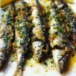 Mediterranean garlic and herb crusted roasted sardines on a plate