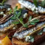 Mediterranean sardine toast garnished with herbs and served on crispy bread