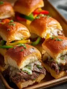 Philly Cheesesteak Sliders 3 Philly Cheesesteak Sliders served on a platter with toppings