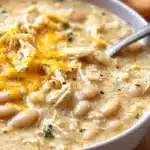A bowl of creamy white chicken chili topped with cilantro and lime.