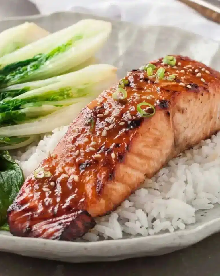 Asian Glazed Salmon drizzled with sticky maple-soy glaze on a white plate