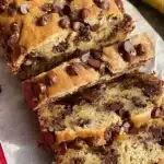 Delicious slice of chocolate chip banana bread on a wooden table