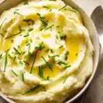 Delicious creamy mashed potato dish served in a bowl with a sprig of parsley