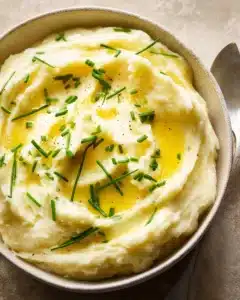 Delicious creamy mashed potato dish served in a bowl with a sprig of parsley