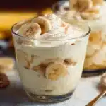 High Protein Banana Pudding topped with fresh bananas and whipped cream