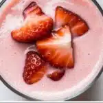 High-protein strawberry peach smoothie in a glass with fresh fruit