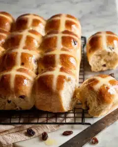 Freshly baked Hot Cross Buns cooling on a wire rack