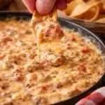 Sausage cheese dip in a bowl surrounded by tortilla chips, perfect for sharing.