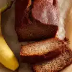 Slice of JB's delicious homemade banana bread on a wooden table