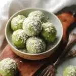 Homemade matcha coconut balls on a plate, showcasing their vibrant green color.