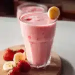 Creamy strawberry banana smoothie in a glass with fresh fruits
